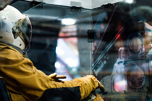 Yellow astronaut suit sitting in a plastic box with a faded dashboard infront of it.