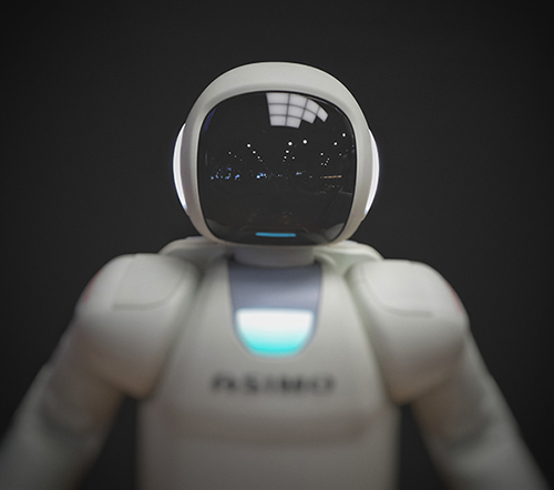 Photo of white robot with large black screen instead of a face.